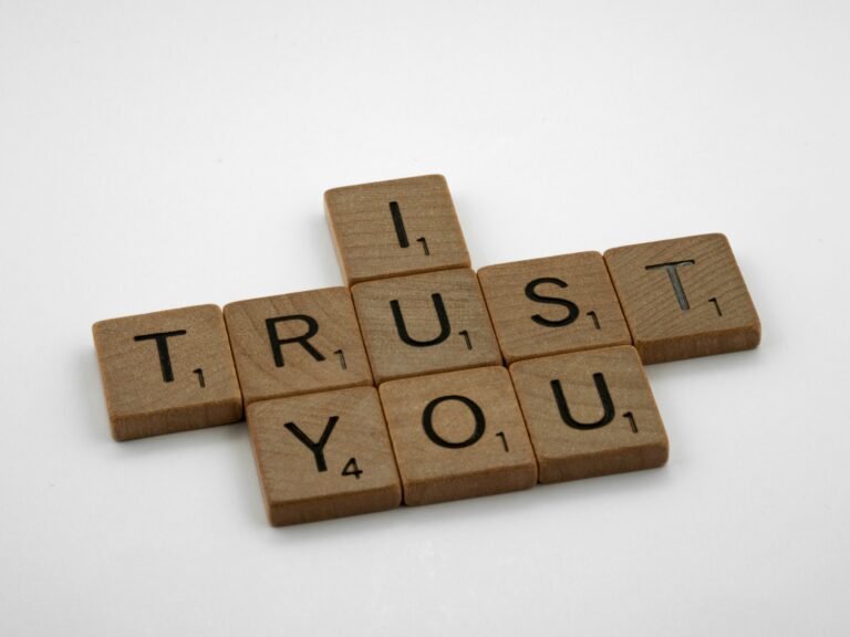 Wooden-letter tiles spell TRUST YOU on a white background.