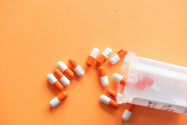 Pills spilling from a bottle on an orange background for daily walk devotion.